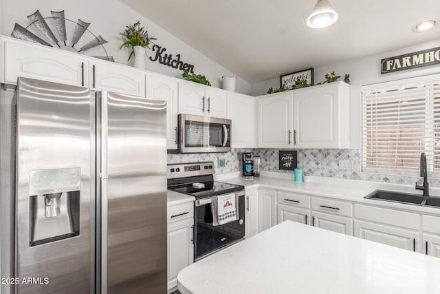 kitchen featuring decorative backsplash, white cabinetry, stainless steel appliances, and a sink