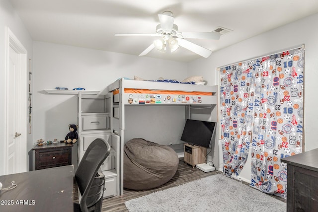 bedroom with a ceiling fan, visible vents, and wood finished floors