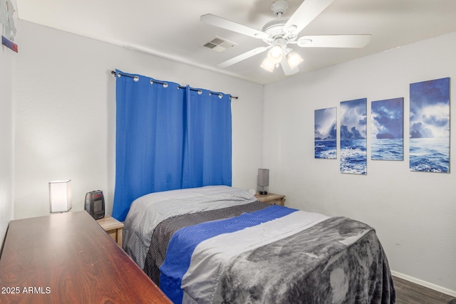 bedroom with a ceiling fan, visible vents, baseboards, and wood finished floors