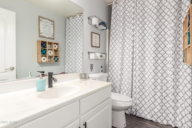 full bathroom featuring wood finished floors, vanity, toilet, and curtained shower