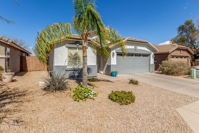 view of front facade with an attached garage, fence, concrete driveway, and stucco siding