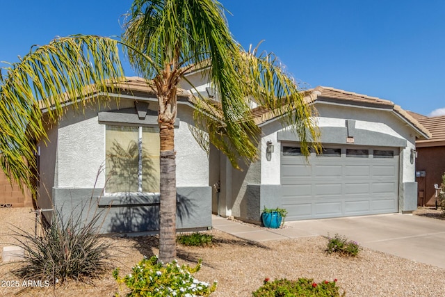 view of side of home featuring a garage, driveway, a tiled roof, and stucco siding