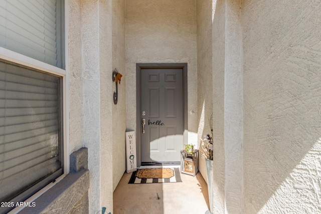 doorway to property featuring stucco siding