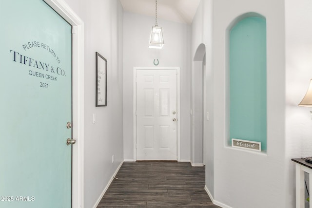 hall with dark wood-style flooring and baseboards