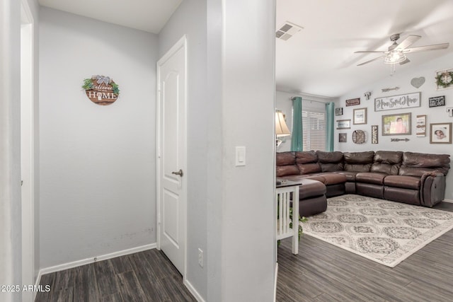 living area featuring baseboards, visible vents, lofted ceiling, ceiling fan, and wood finished floors