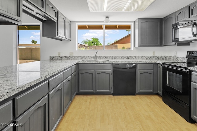 1334 S Glenview Cir, Mesa, AZ 85204 - kitchen with black appliances, a sink, light wood-style floors, and light stone counters
