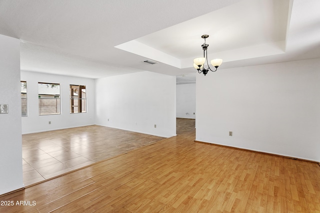 1334 S Glenview Cir, Mesa, AZ 85204 - spare room with a chandelier, a tray ceiling, wood finished floors, and baseboards