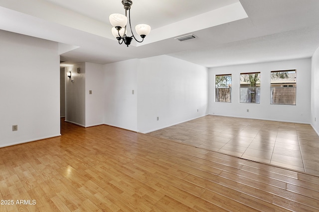 1334 S Glenview Cir, Mesa, AZ 85204 - spare room with light wood-type flooring, a chandelier, baseboards, and a raised ceiling
