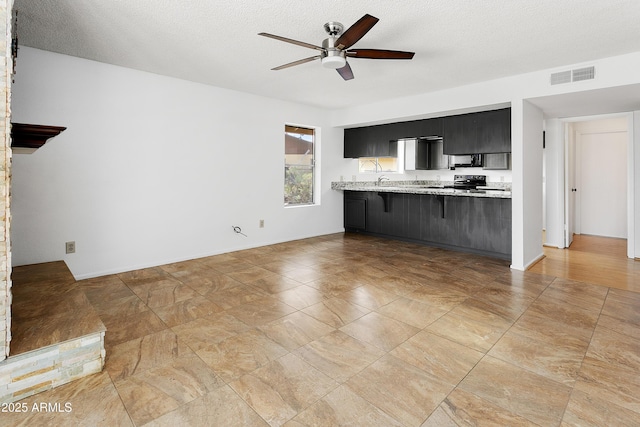 1334 S Glenview Cir, Mesa, AZ 85204 - unfurnished living room featuring a ceiling fan and a textured ceiling