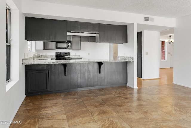 1334 S Glenview Cir, Mesa, AZ 85204 - kitchen with black appliances, a peninsula, a chandelier, and light stone countertops