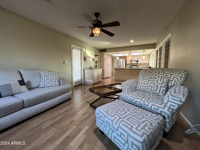 living room featuring wood-type flooring and ceiling fan