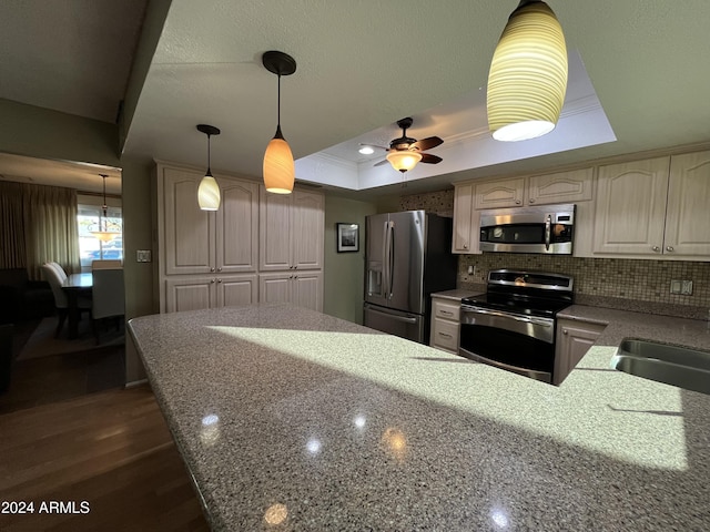 kitchen with sink, stainless steel appliances, a raised ceiling, tasteful backsplash, and crown molding