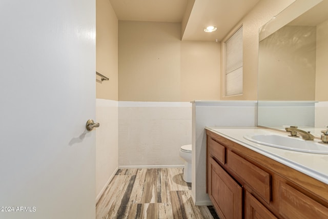 bathroom with hardwood / wood-style floors, vanity, and toilet