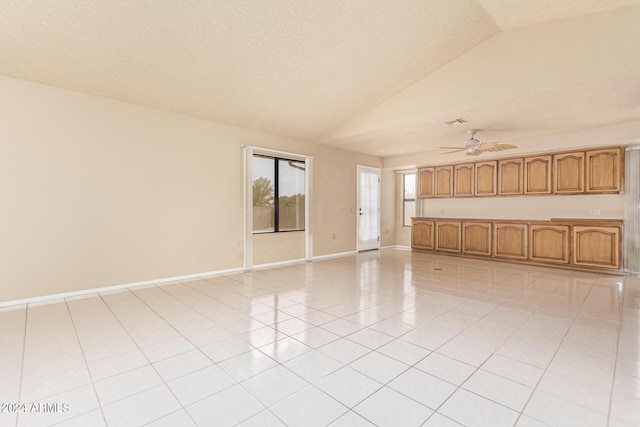 unfurnished living room featuring lofted ceiling, light tile patterned floors, and a textured ceiling