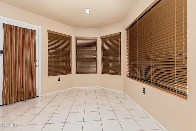 empty room featuring light tile patterned floors and baseboards