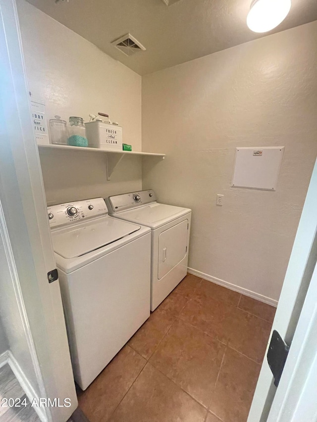 laundry room with light tile patterned floors and washing machine and clothes dryer