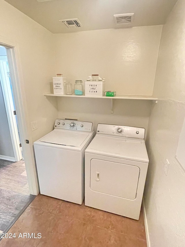 clothes washing area featuring washing machine and clothes dryer and light tile patterned flooring