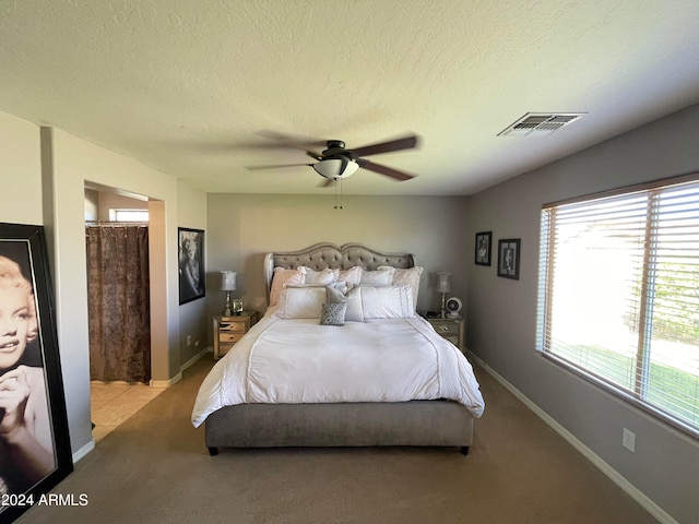 bedroom with multiple windows, ceiling fan, and light carpet