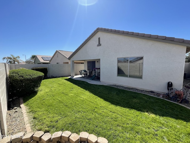 rear view of property featuring a patio area and a lawn