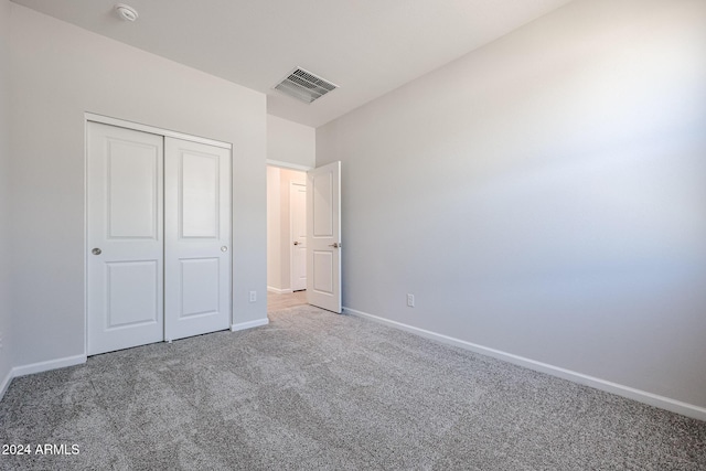 unfurnished bedroom with carpet flooring and a closet