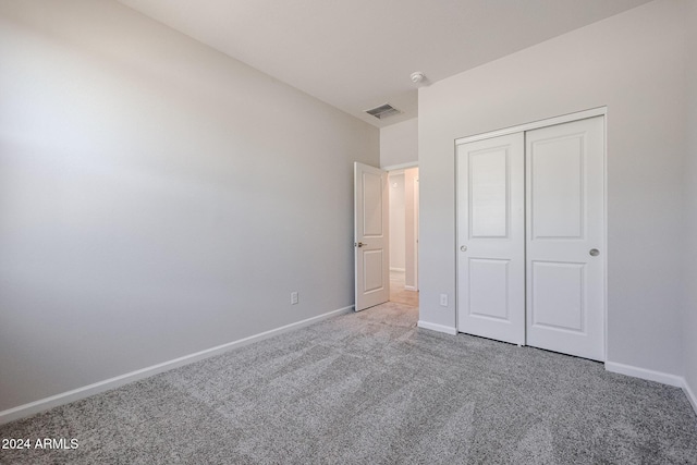 unfurnished bedroom with carpet flooring and a closet