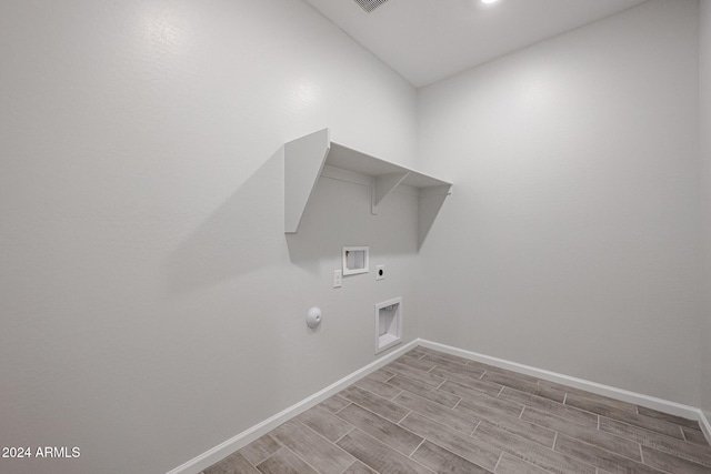 laundry room featuring hookup for an electric dryer, light hardwood / wood-style floors, gas dryer hookup, and hookup for a washing machine