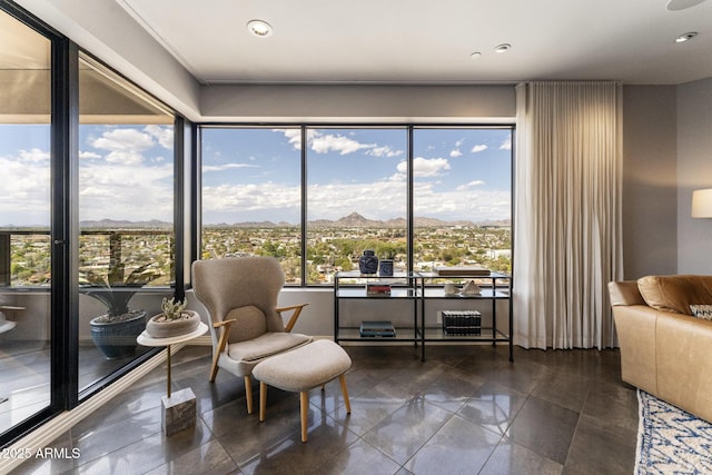 living area with recessed lighting, a mountain view, and a wealth of natural light