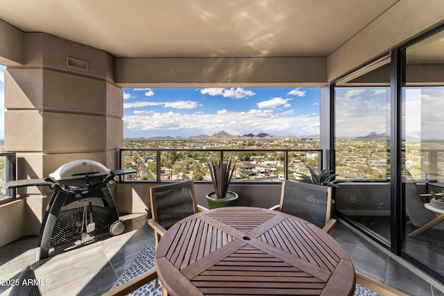 balcony featuring a mountain view and outdoor dining space