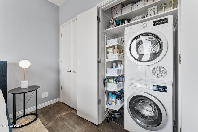 laundry room featuring baseboards, laundry area, and stacked washer and dryer