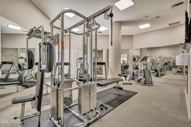 exercise room featuring visible vents, carpet flooring, and a wealth of natural light