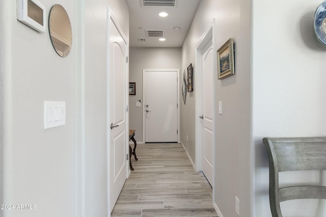 corridor with baseboards, light wood-type flooring, visible vents, and recessed lighting