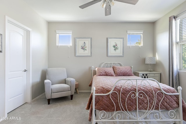 bedroom featuring carpet floors, multiple windows, baseboards, and a ceiling fan