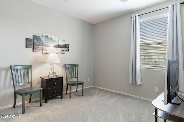 sitting room with visible vents, baseboards, and light colored carpet