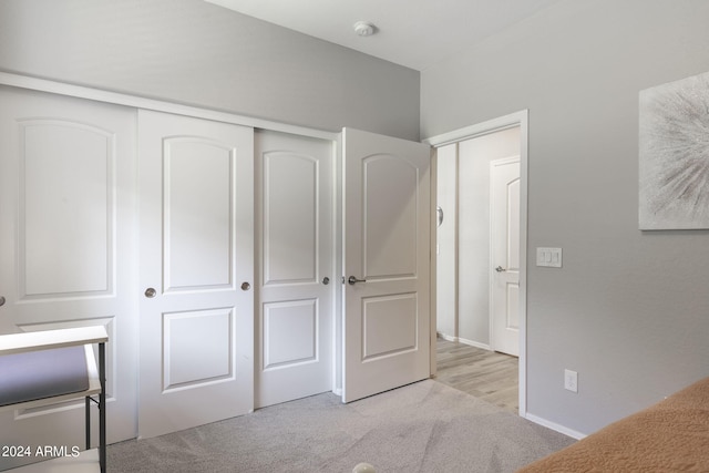 unfurnished bedroom featuring a closet and light colored carpet