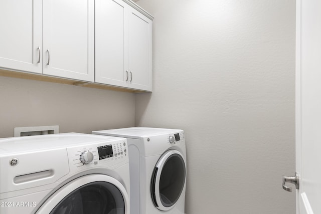 washroom with cabinets and washer and clothes dryer