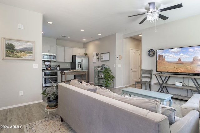 living room with ceiling fan and light hardwood / wood-style flooring