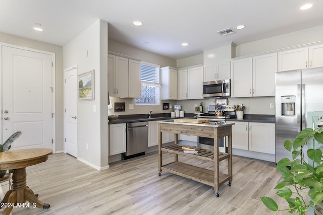 kitchen featuring recessed lighting, visible vents, appliances with stainless steel finishes, light wood finished floors, and dark countertops