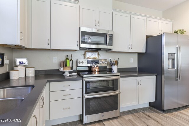 kitchen featuring appliances with stainless steel finishes, white cabinetry, and light hardwood / wood-style flooring