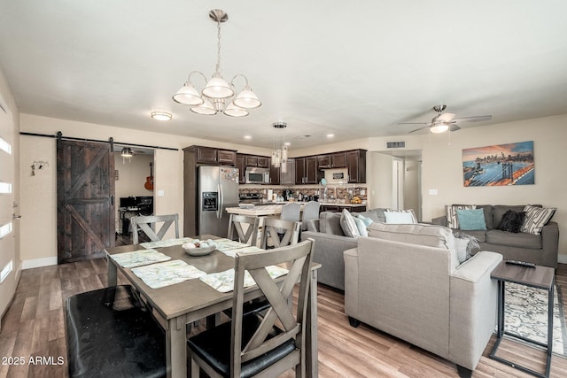 11450 E Elton Ave, Mesa, AZ 85208 - dining area with a barn door, a chandelier, ceiling fan, and light wood-type flooring
