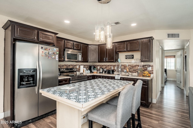 11450 E Elton Ave, Mesa, AZ 85208 - kitchen featuring appliances with stainless steel finishes, dark brown cabinetry, light countertops, wood finished floors, and tasteful backsplash