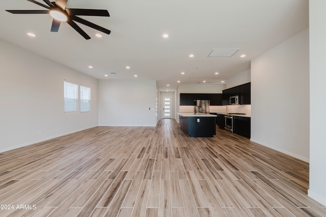 unfurnished living room with ceiling fan and light hardwood / wood-style flooring