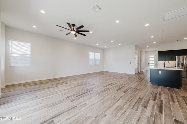 unfurnished living room with ceiling fan and light hardwood / wood-style floors