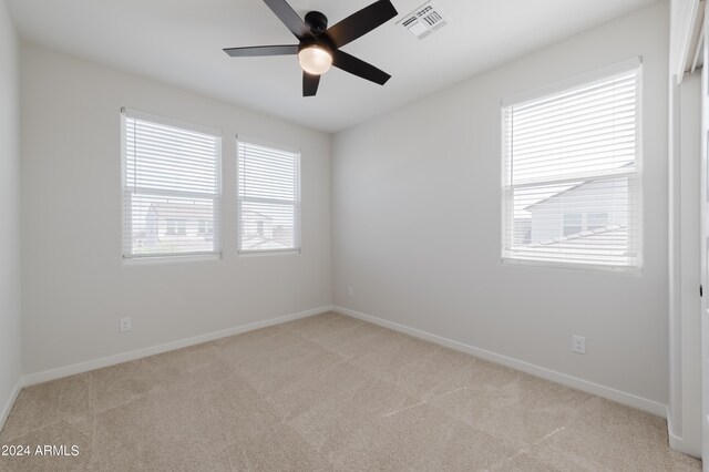 carpeted spare room featuring ceiling fan