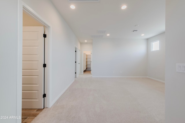 unfurnished room featuring light carpet