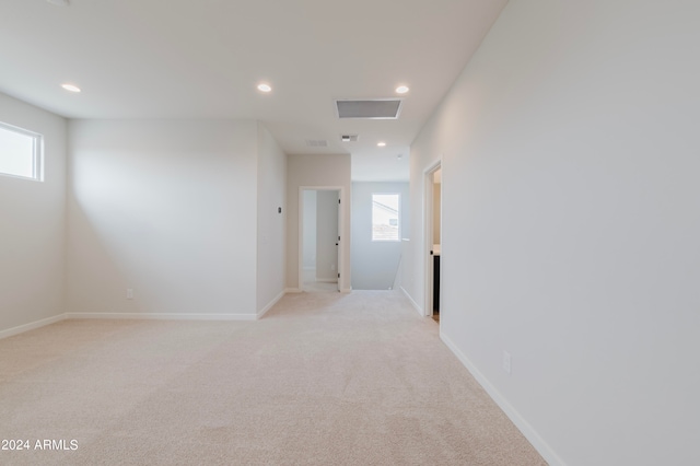 interior space featuring light colored carpet and a healthy amount of sunlight