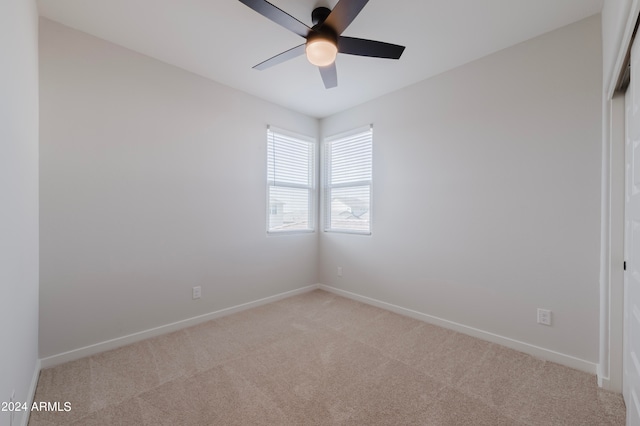 carpeted spare room featuring ceiling fan