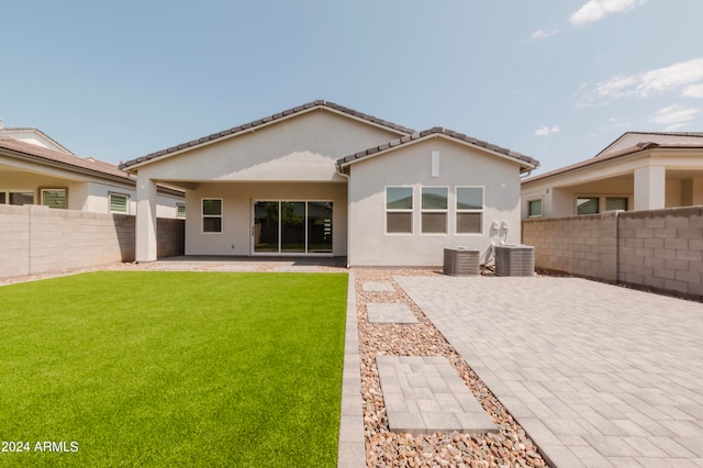 rear view of house with a lawn, a patio, and central AC unit