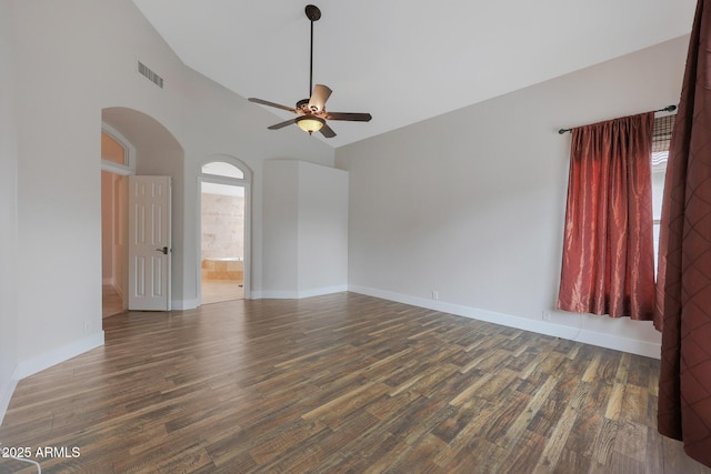 spare room featuring dark wood-type flooring, high vaulted ceiling, and ceiling fan