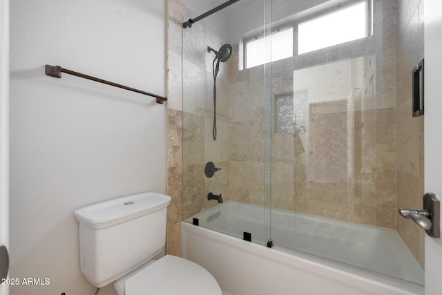 bathroom with toilet and bath / shower combo with glass door