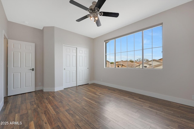 unfurnished bedroom featuring dark wood-type flooring, ceiling fan, and a closet